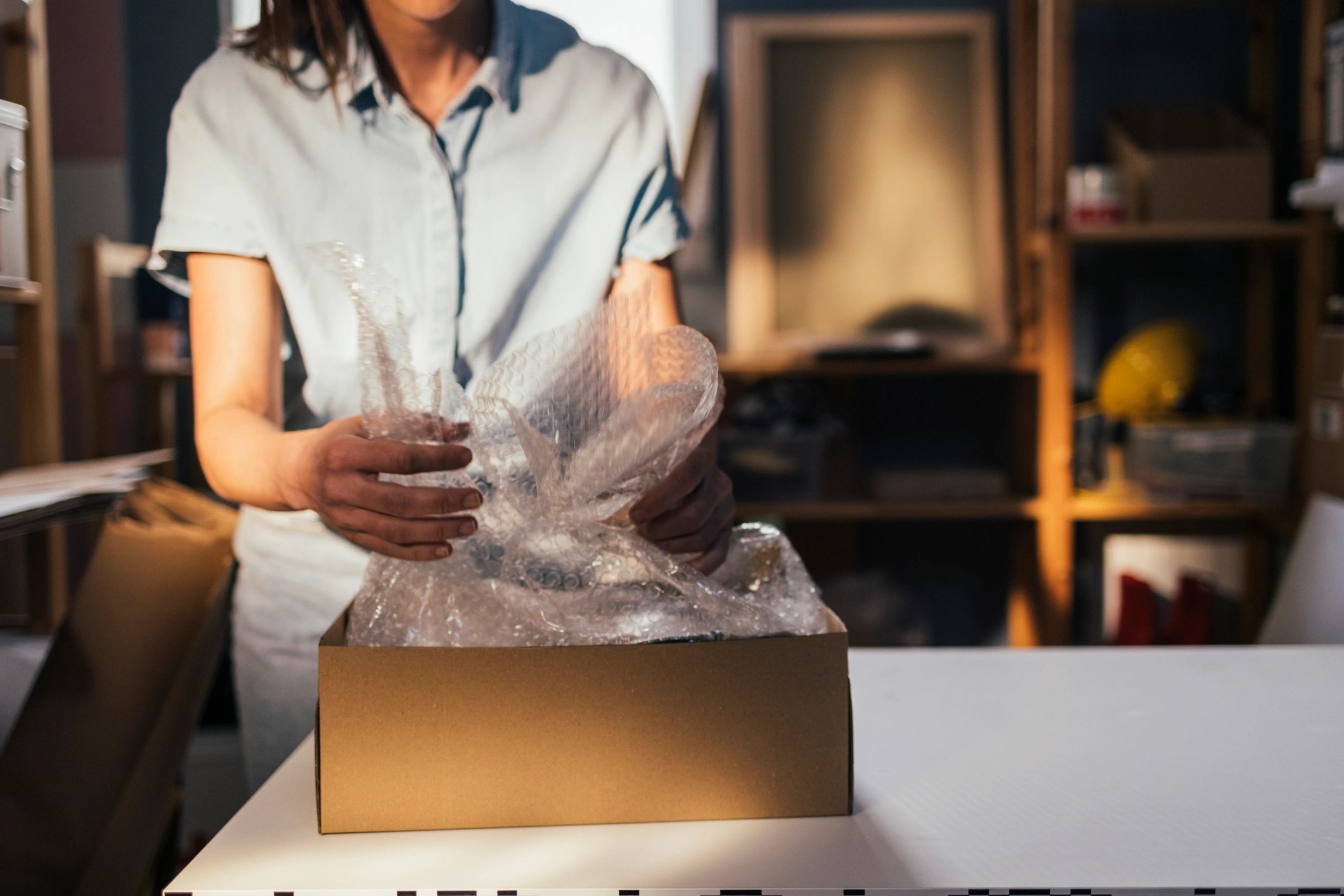 Small business owner packing a box with bubble wrap