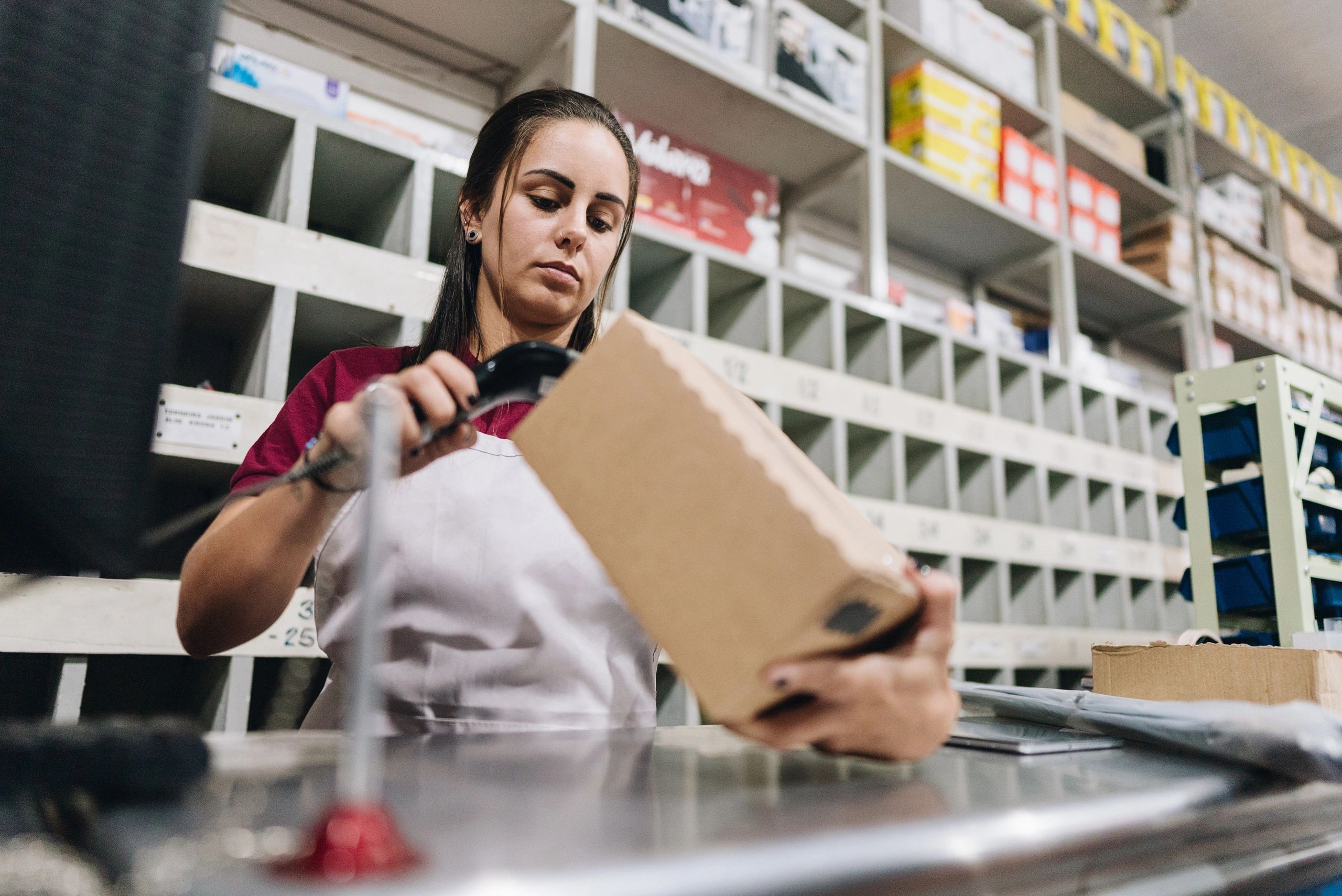 Store associate scanning a package barcode at the counter